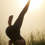 sporty girl standing on head outdoors.