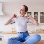young beautiful girl in jeans and a t shirt posing at the kitchen table